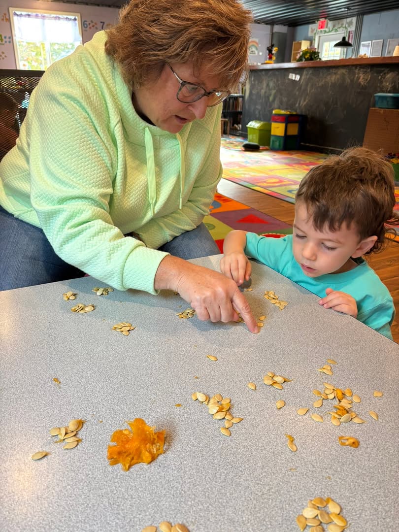 A teacher helping a child at the table